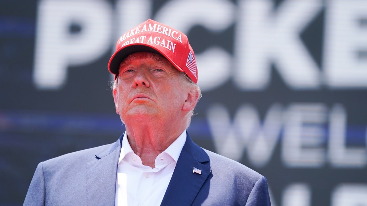 Donald Trump wearing a red make america great again hat