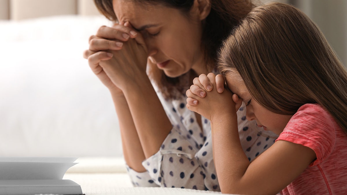 woman and daughter pray