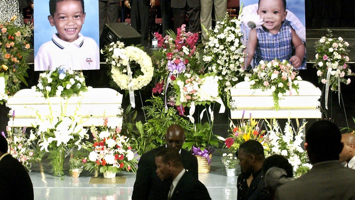 Vincent Brothers walks past caskets of two of his children